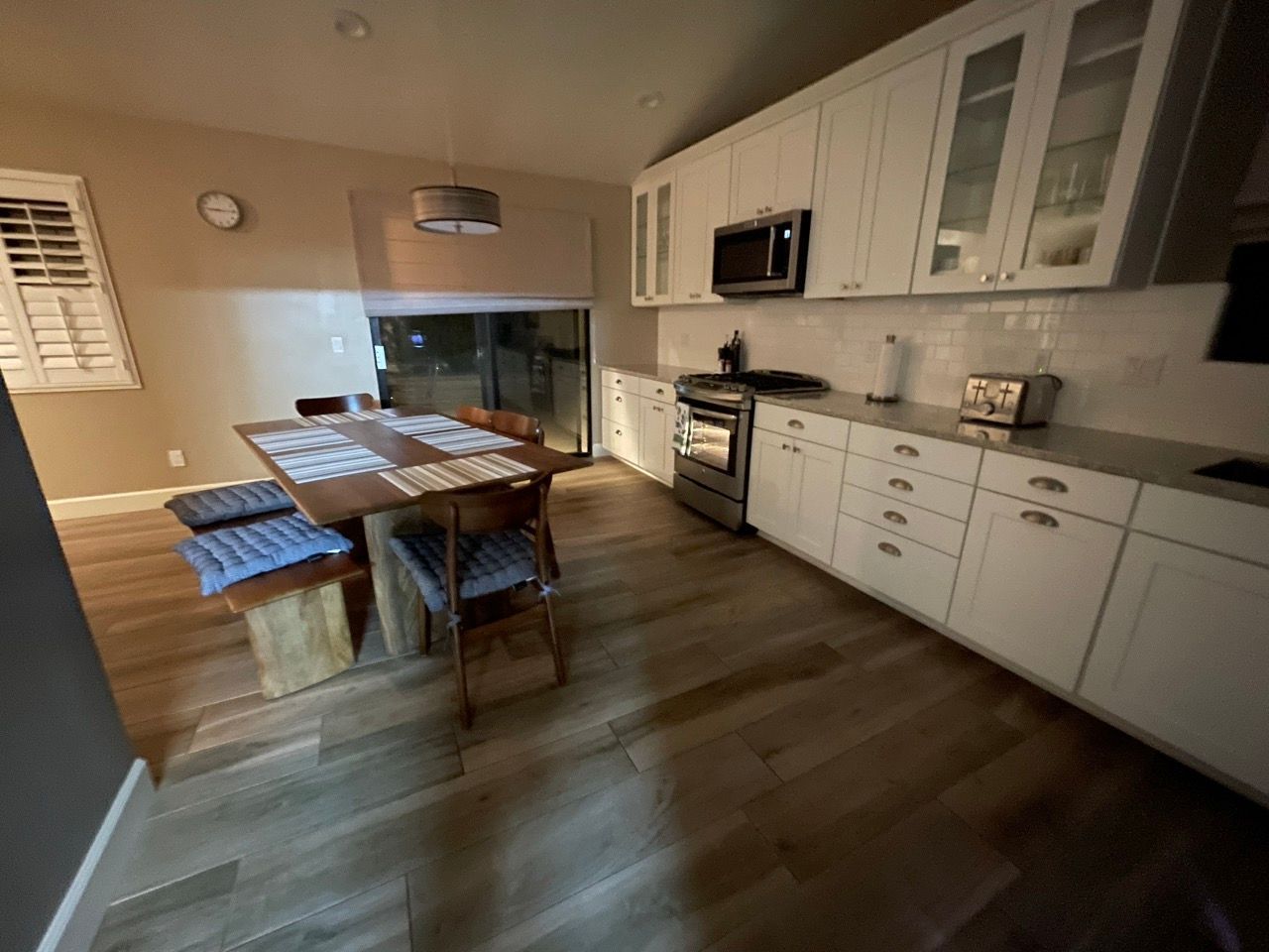 A kitchen with white cabinets and a table and chairs