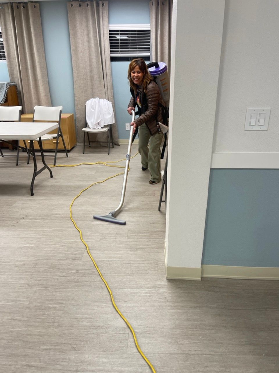 A woman is using a vacuum cleaner to clean a room