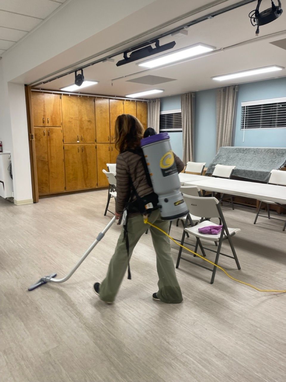 A woman is using a vacuum cleaner in a room