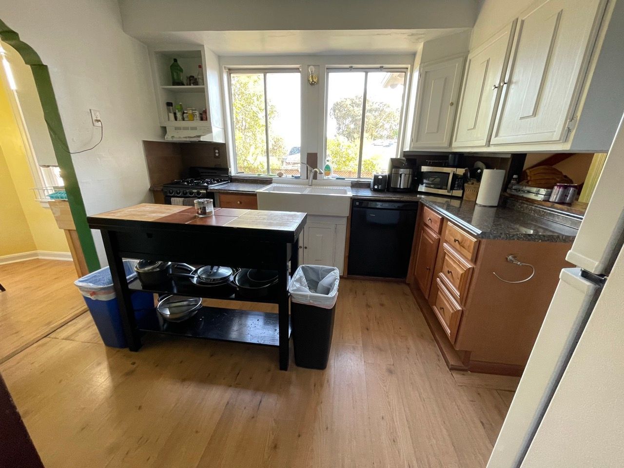 A kitchen with a table and a trash can
