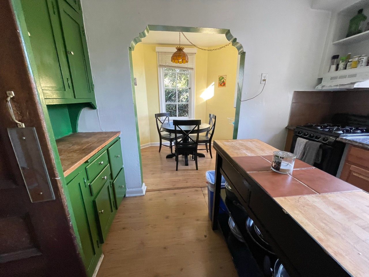 A kitchen with green cabinets and a table and chairs
