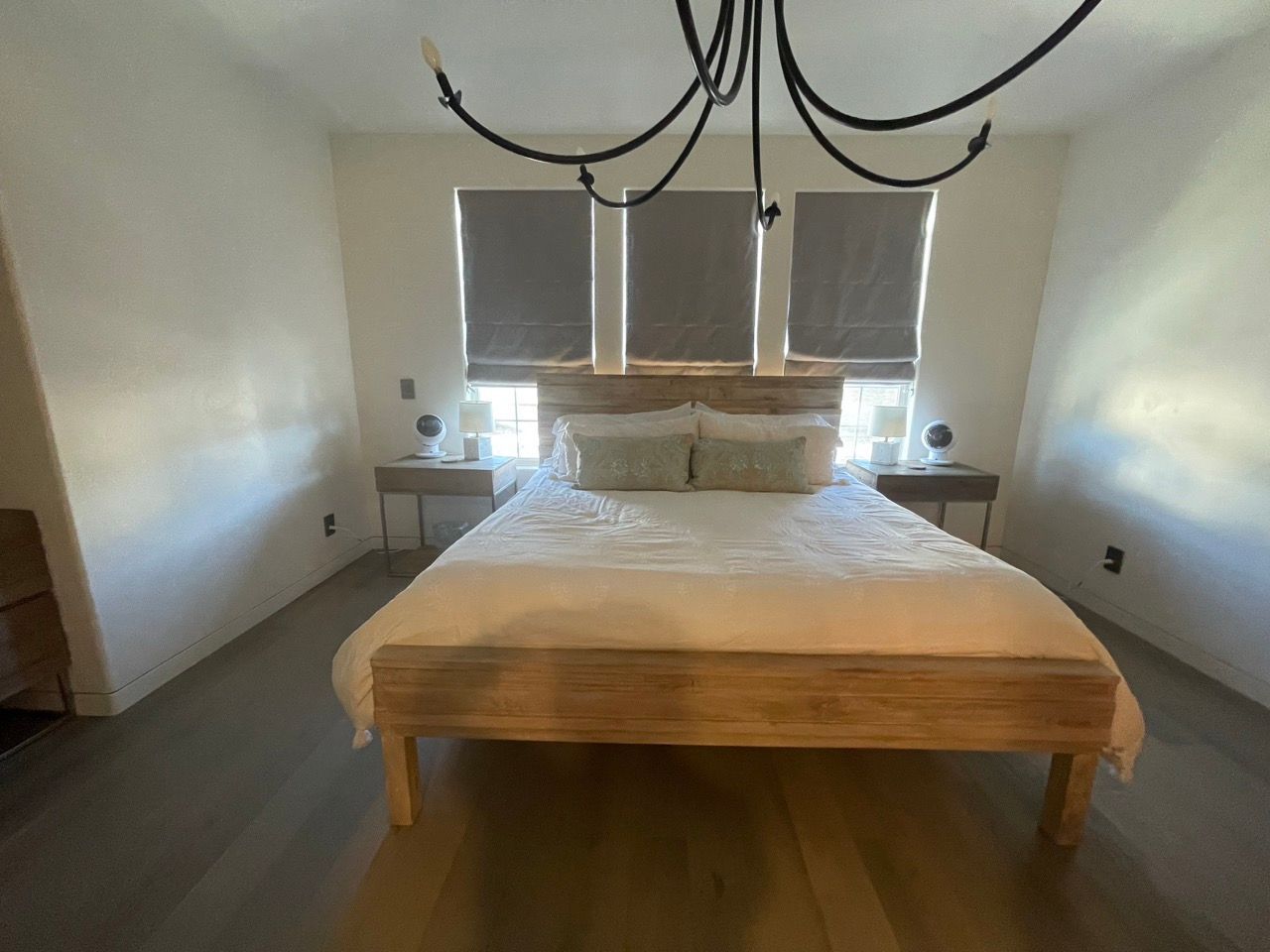A bedroom with a bed and a chandelier hanging from the ceiling
