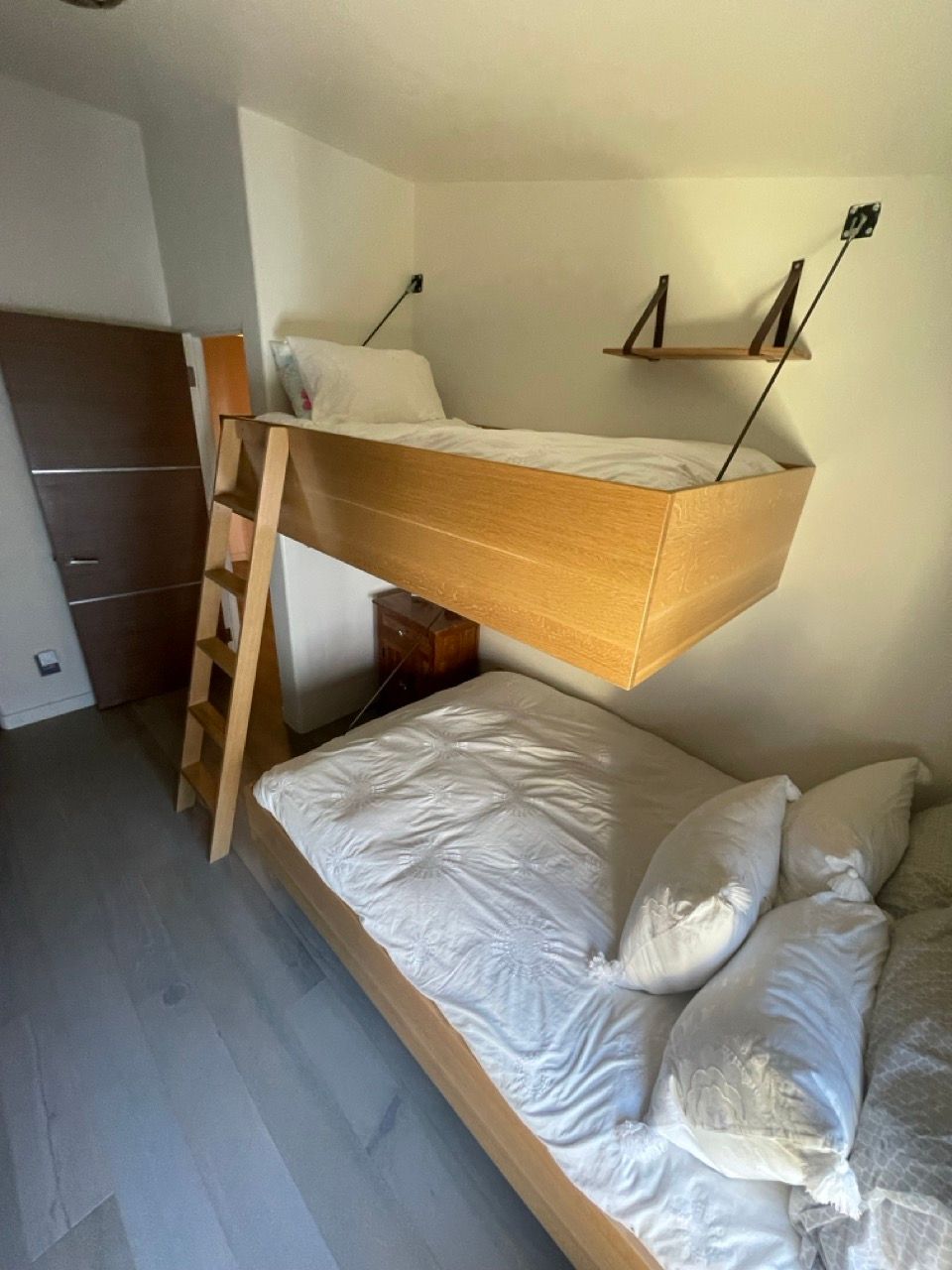 A bedroom with two bunk beds and a ladder