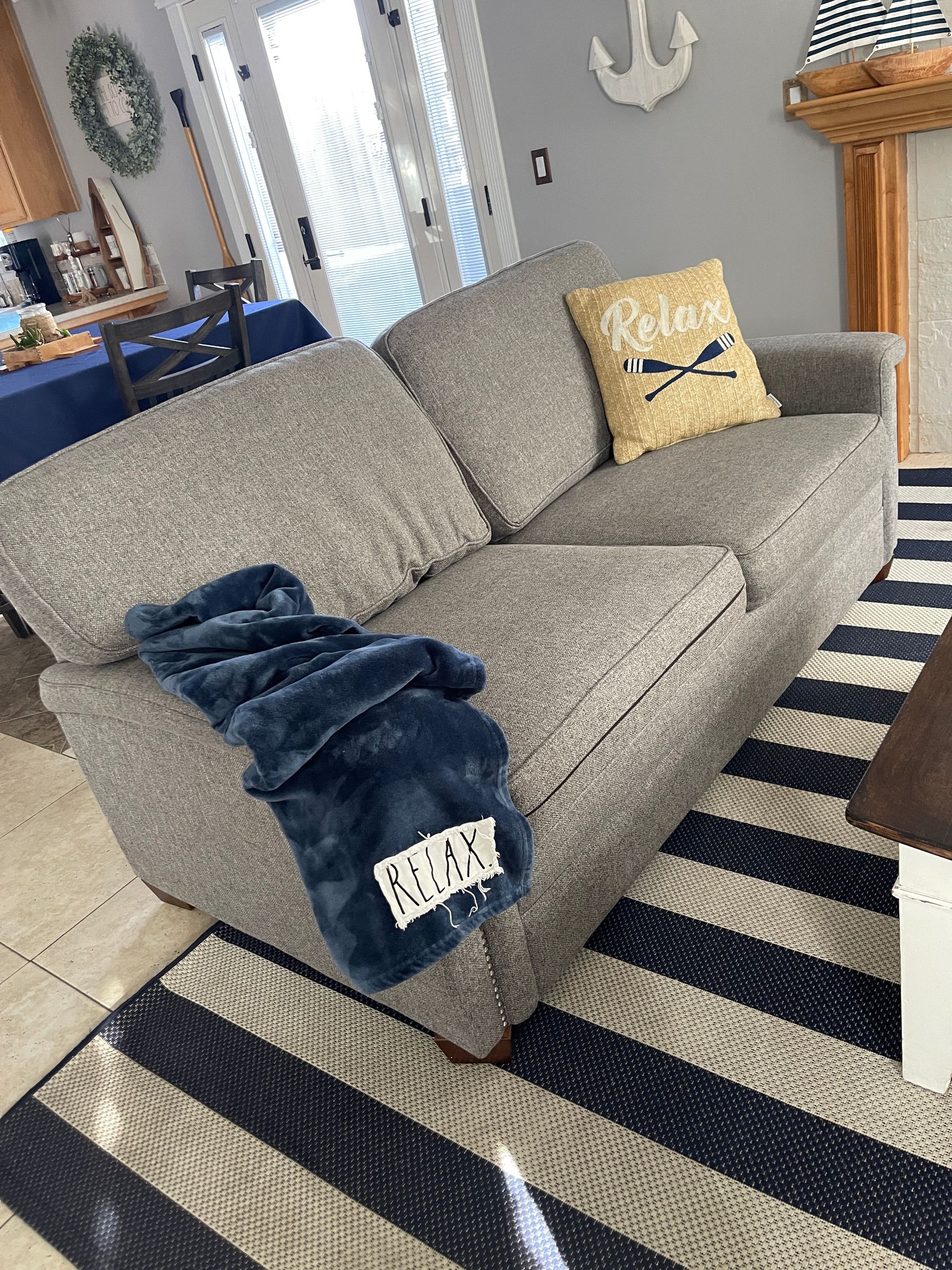 A couch with a pillow that says relax on it