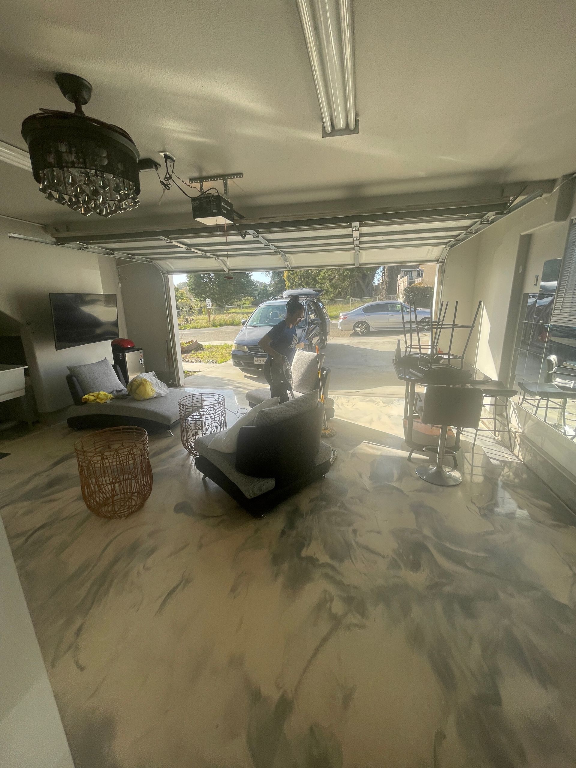 A man is standing in a living room in a garage.