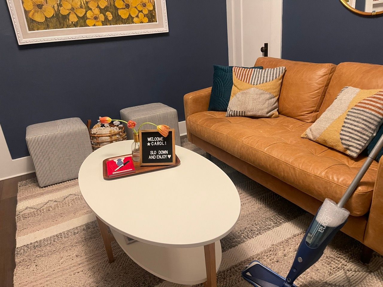 A living room with a brown leather couch and a white coffee table