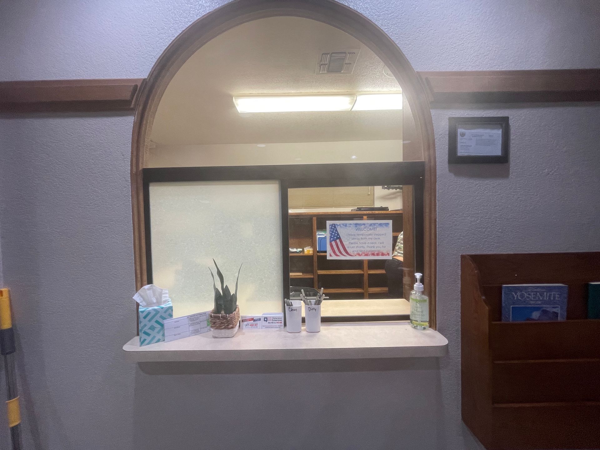 A window in a room with a sign on it that says `` welcome to the library ''.