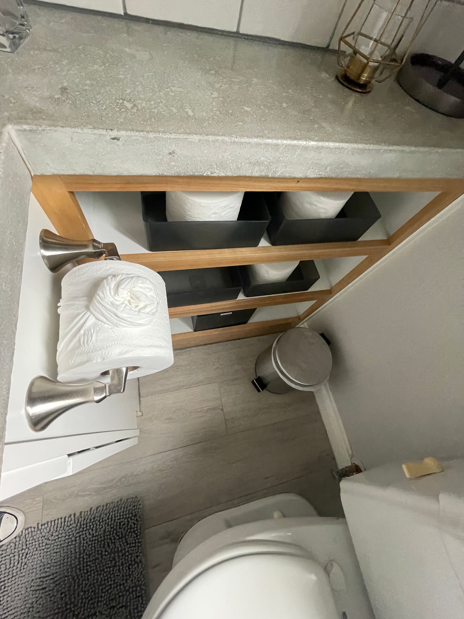 A bathroom with a toilet , sink , and trash can.