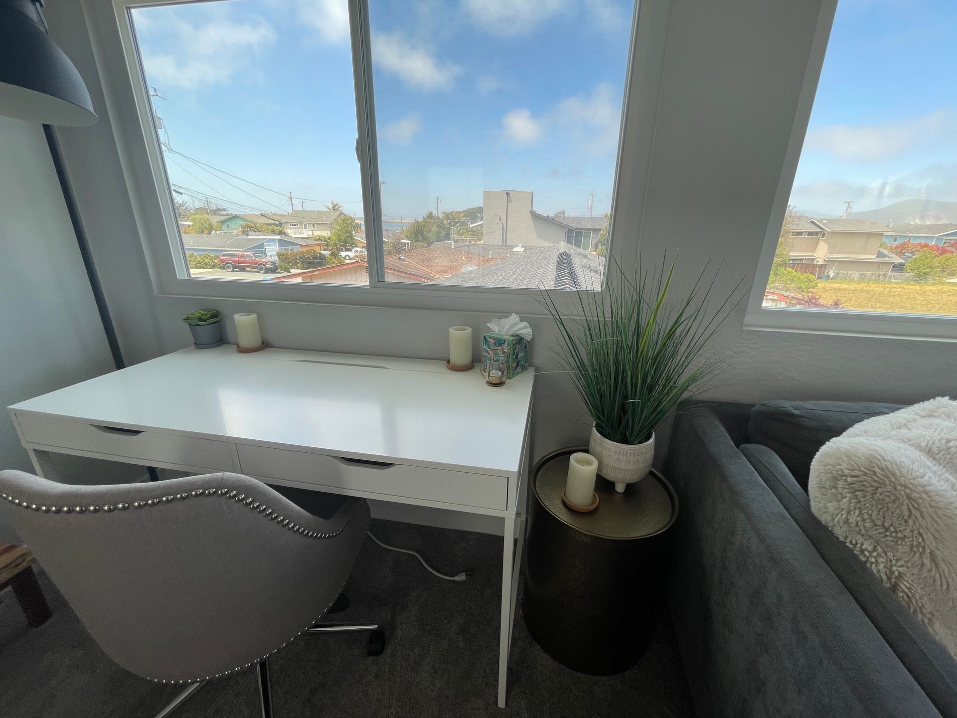 A white desk with a chair in front of a window in a room.
