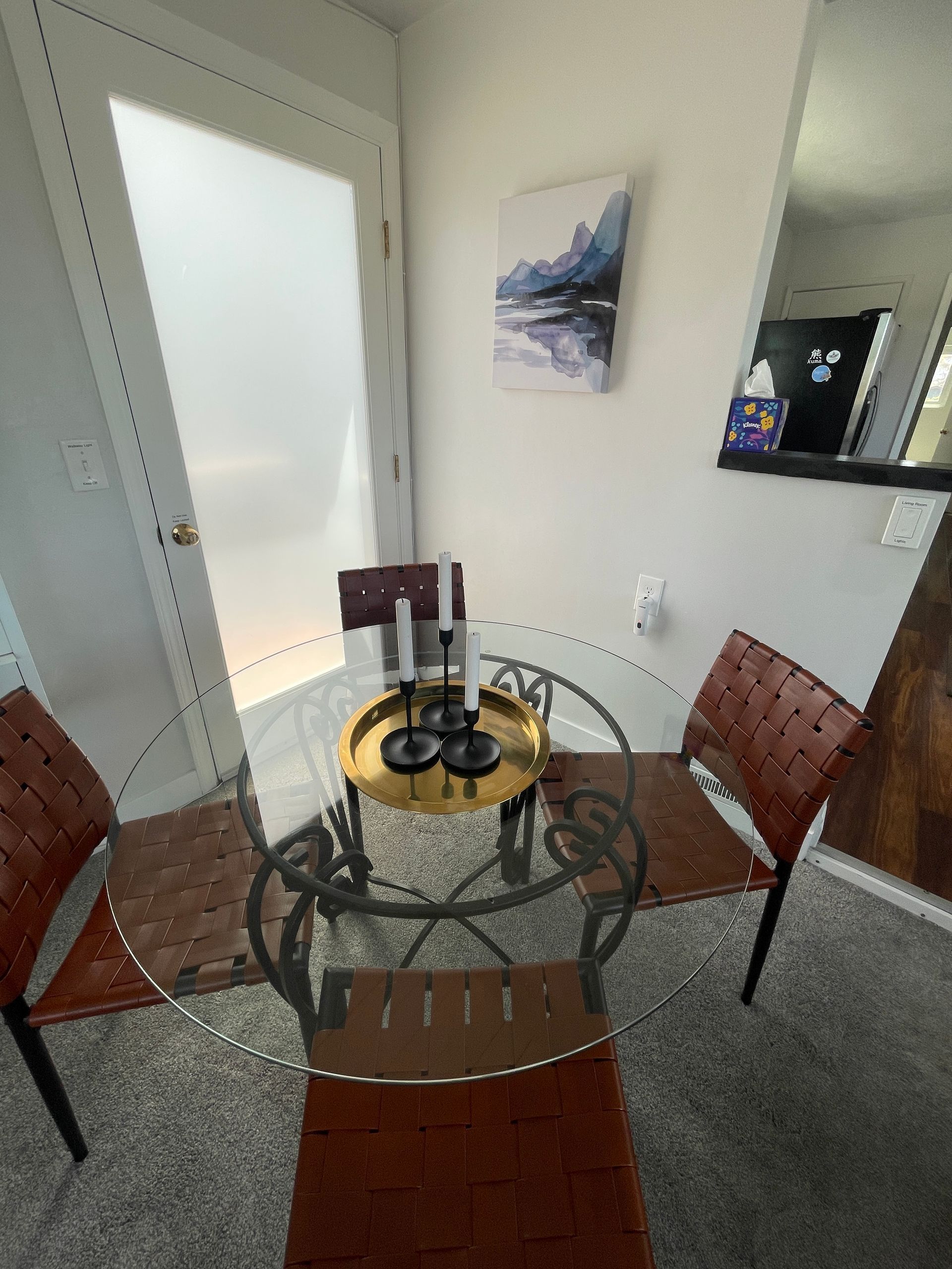 A dining room with a glass table and chairs