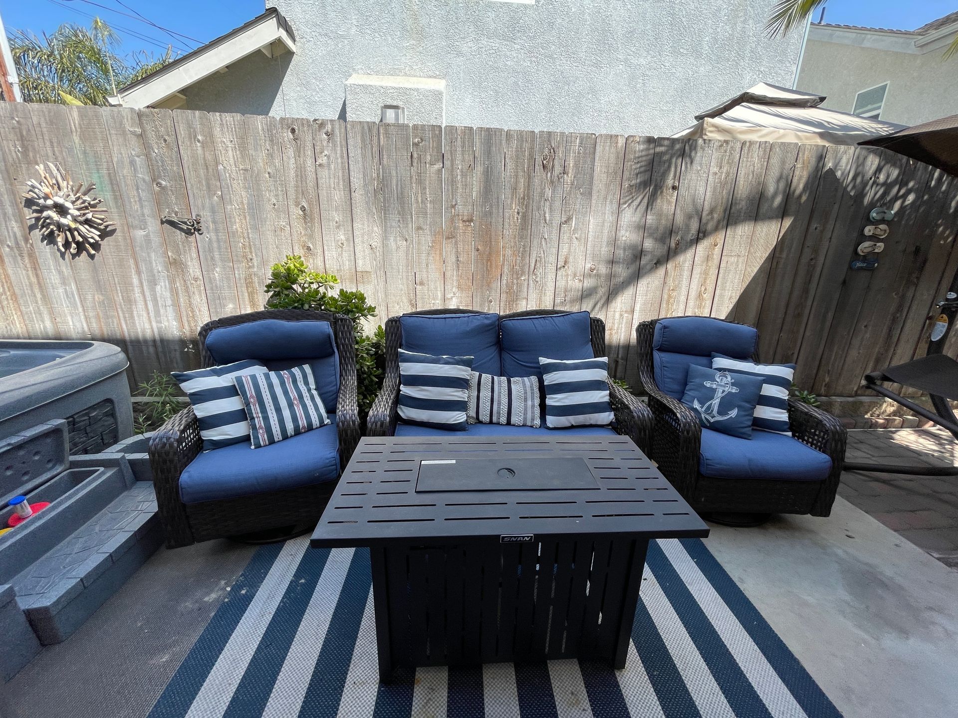 A patio with a couch , chairs , and a table.