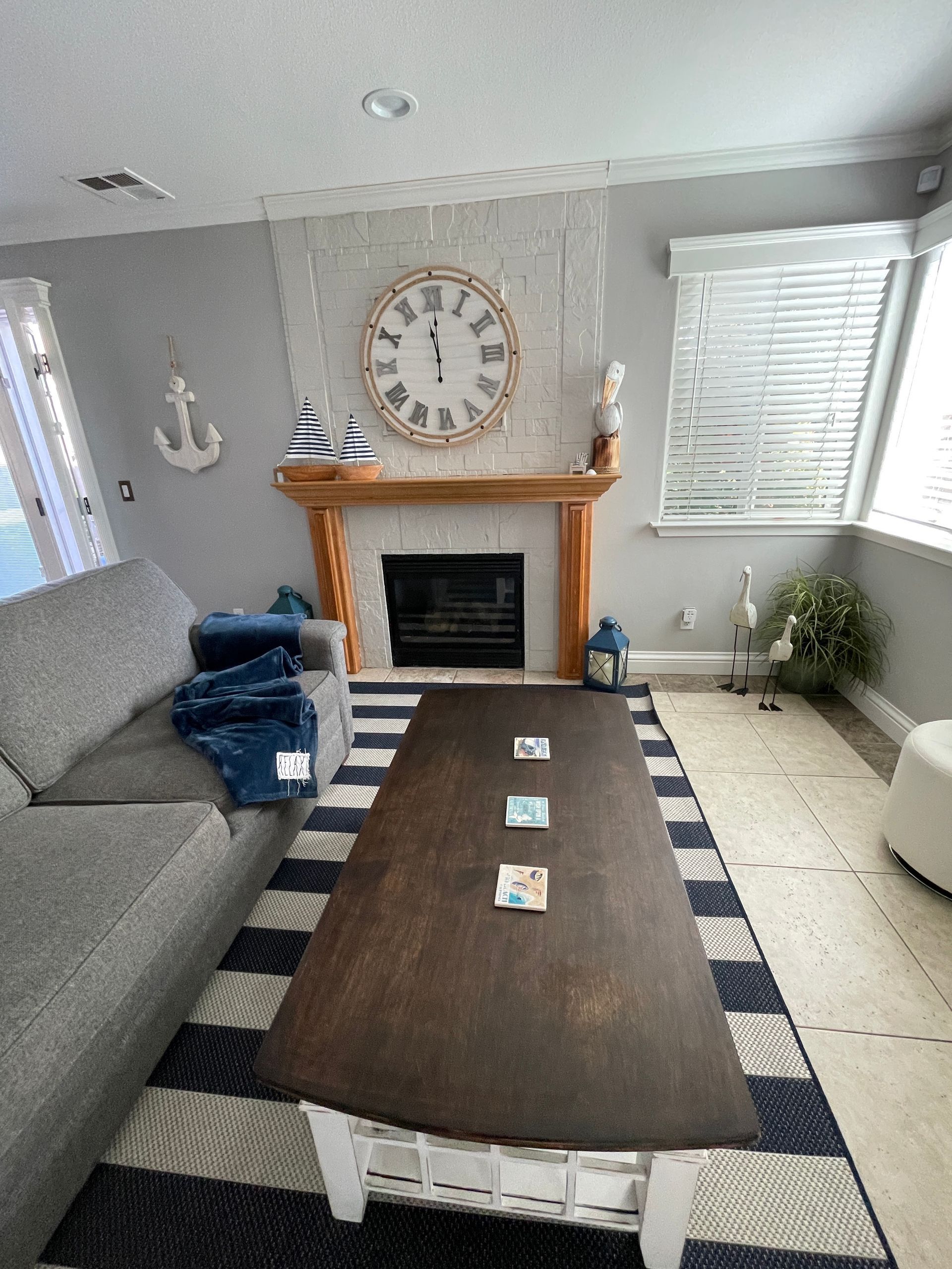 A living room with a fireplace and a clock on the wall