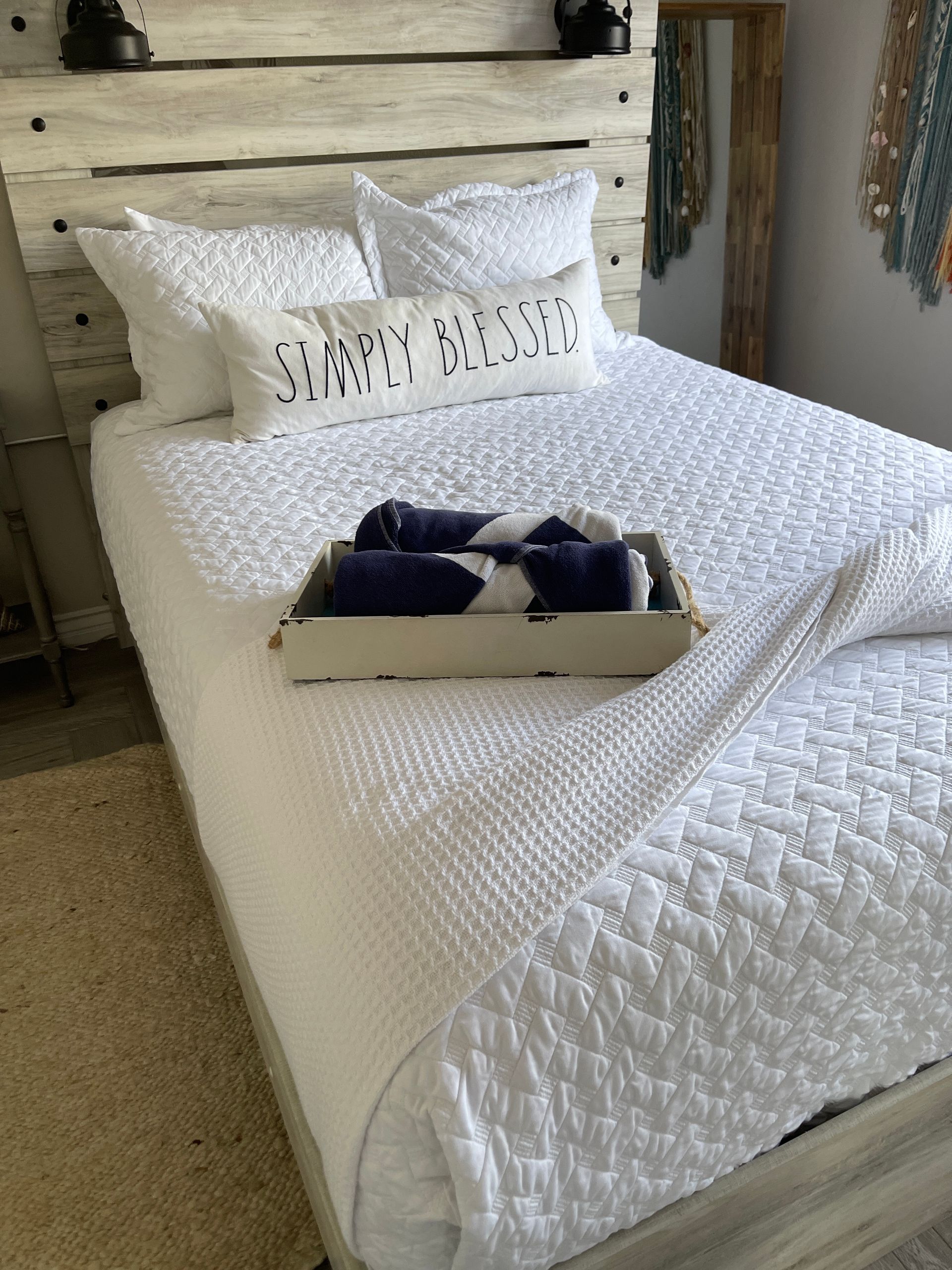 A bed with a pillow that says simply blessed on it