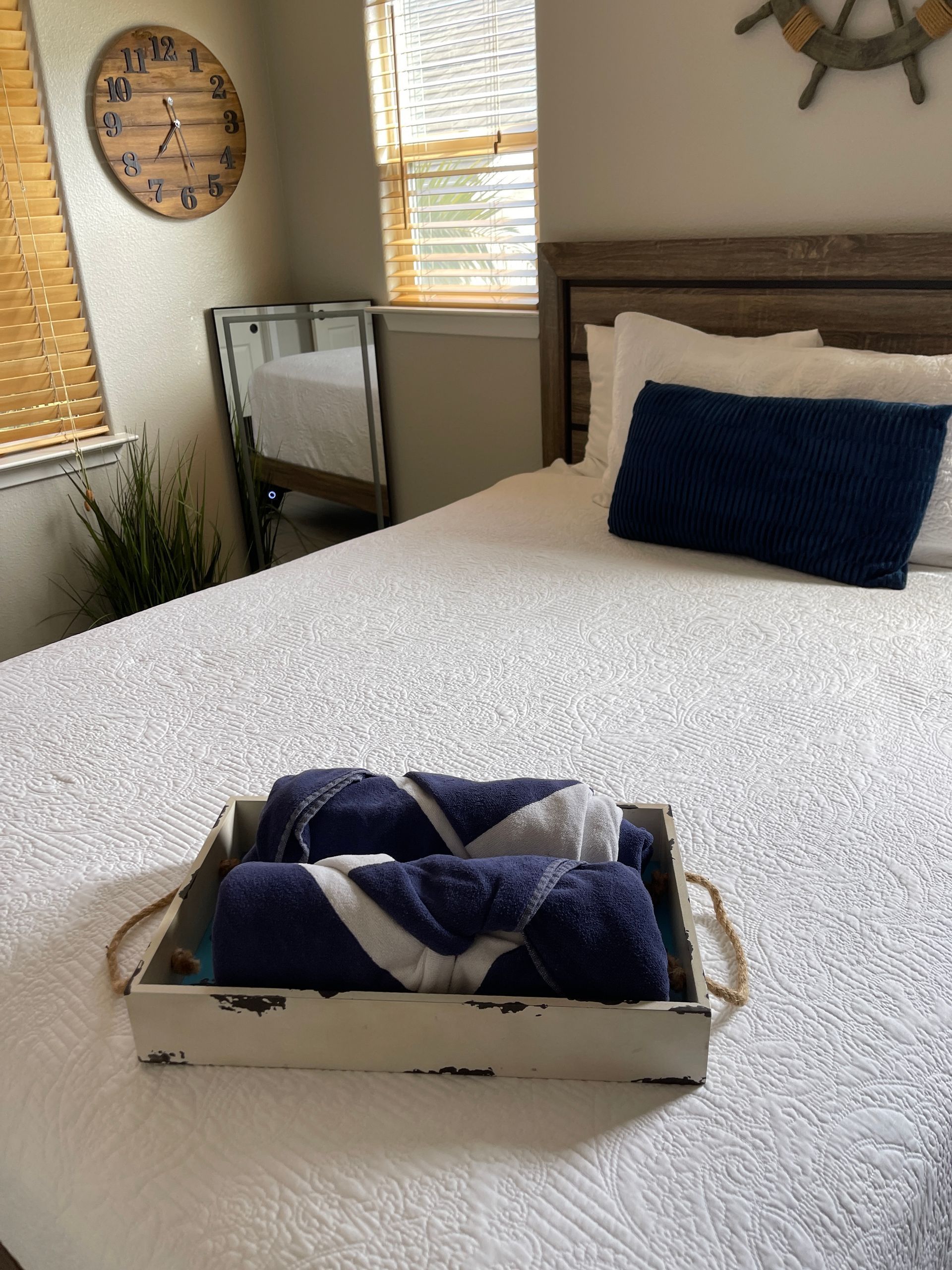 A bed with a clock on the wall above it