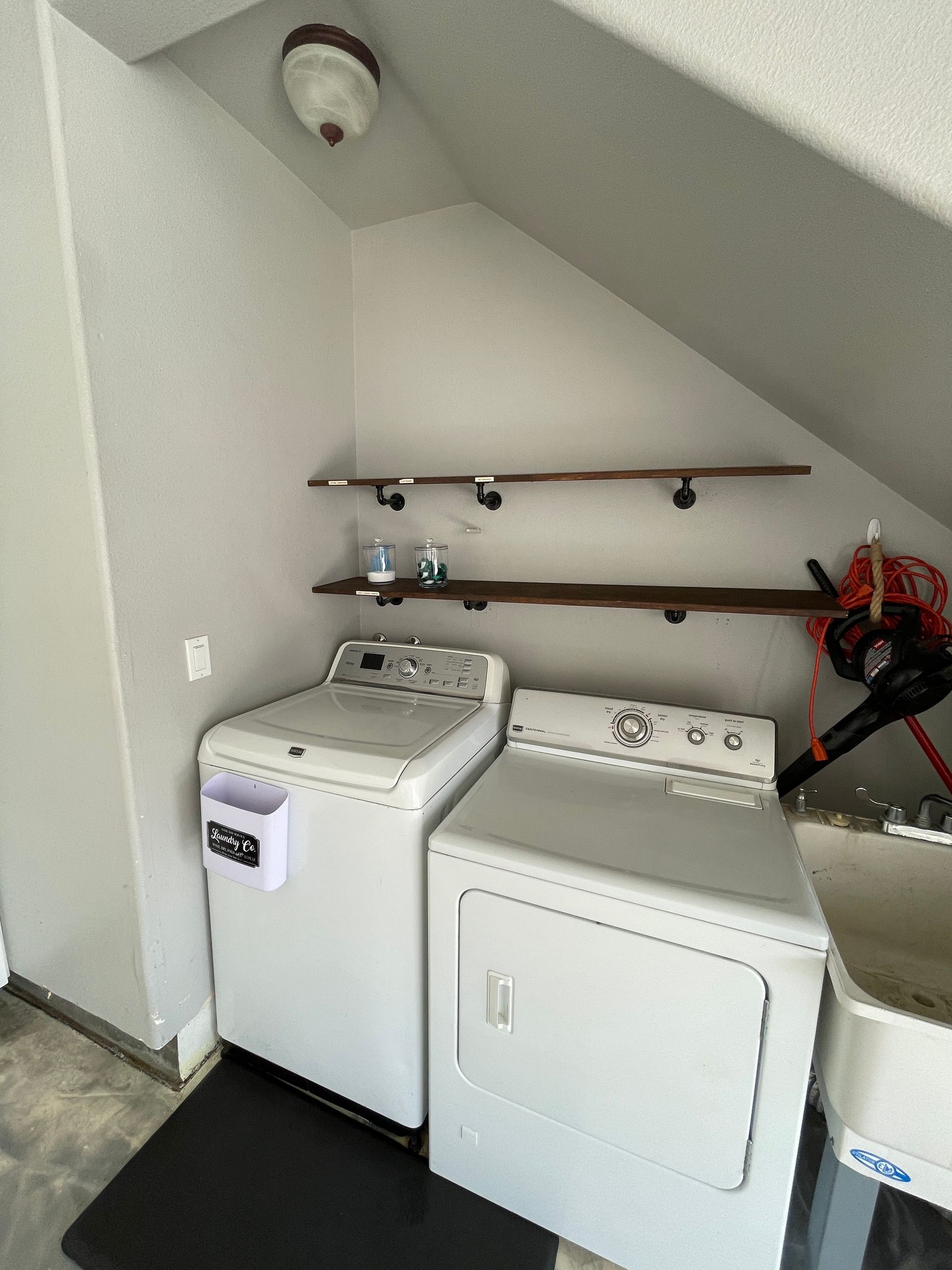 A laundry room with a washer and dryer and a sink