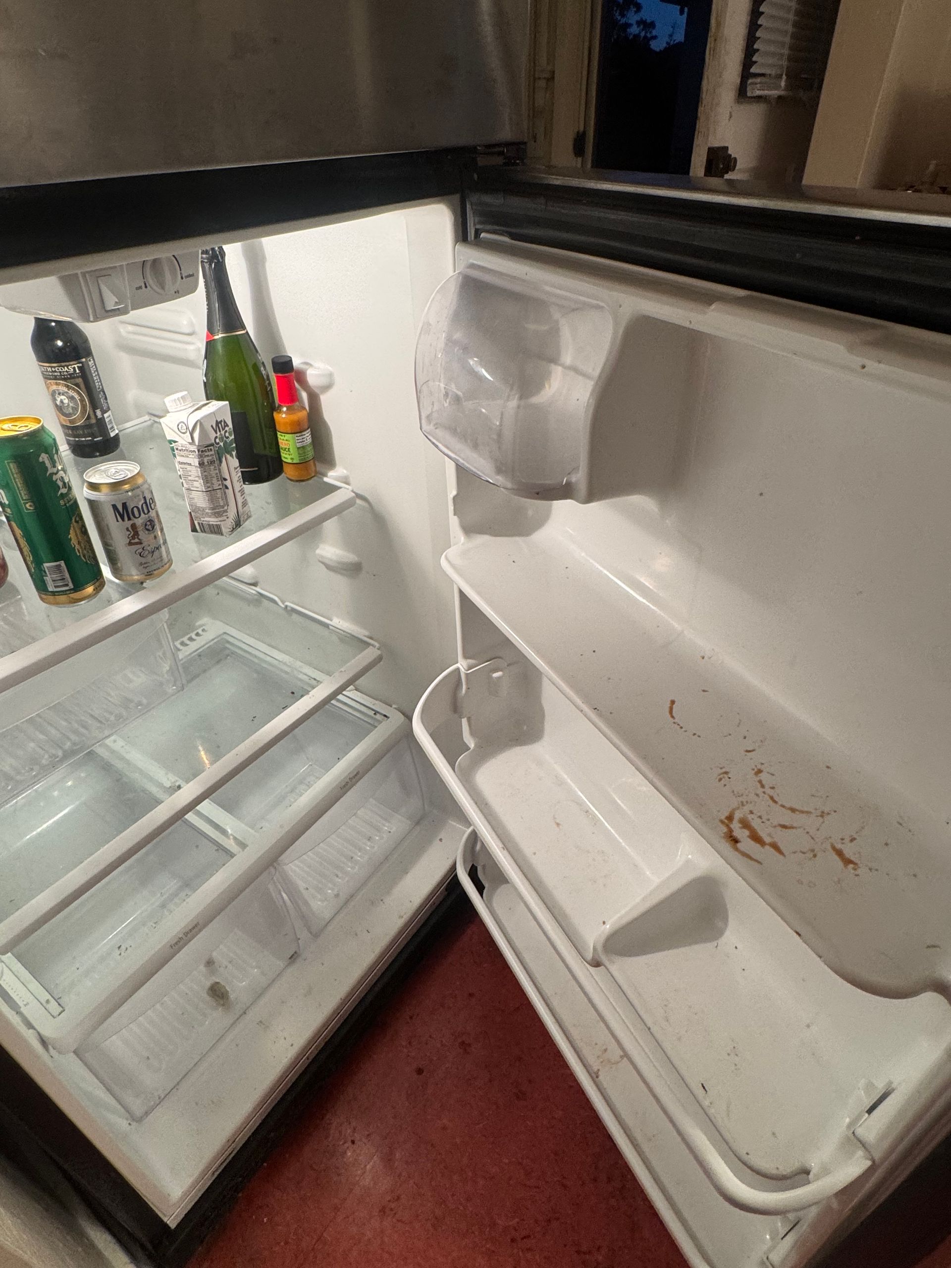An open refrigerator with shelves and some food items inside; interior view.