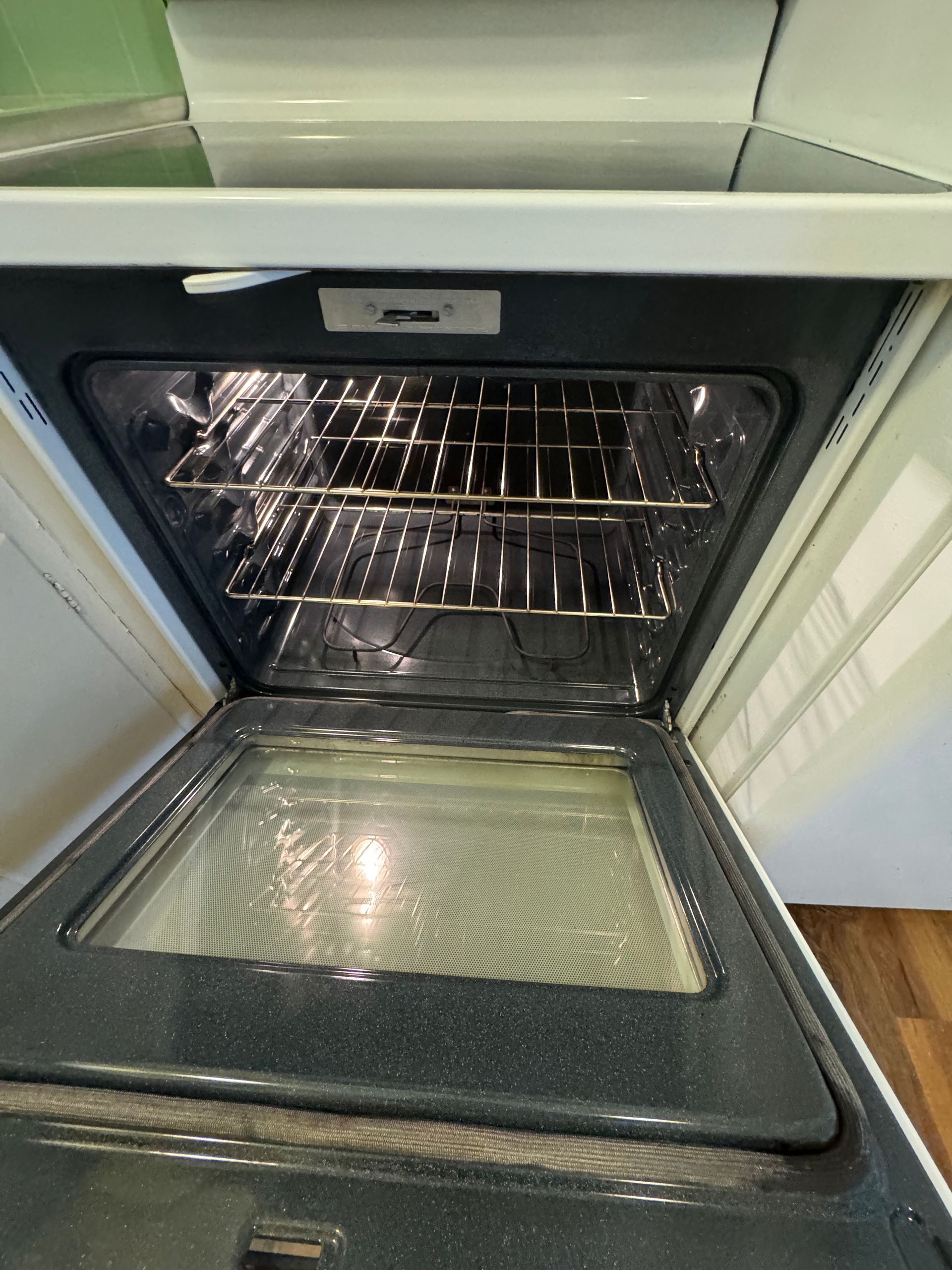 Open oven with racks inside.  Door has a glass panel.  Light shines in the oven.