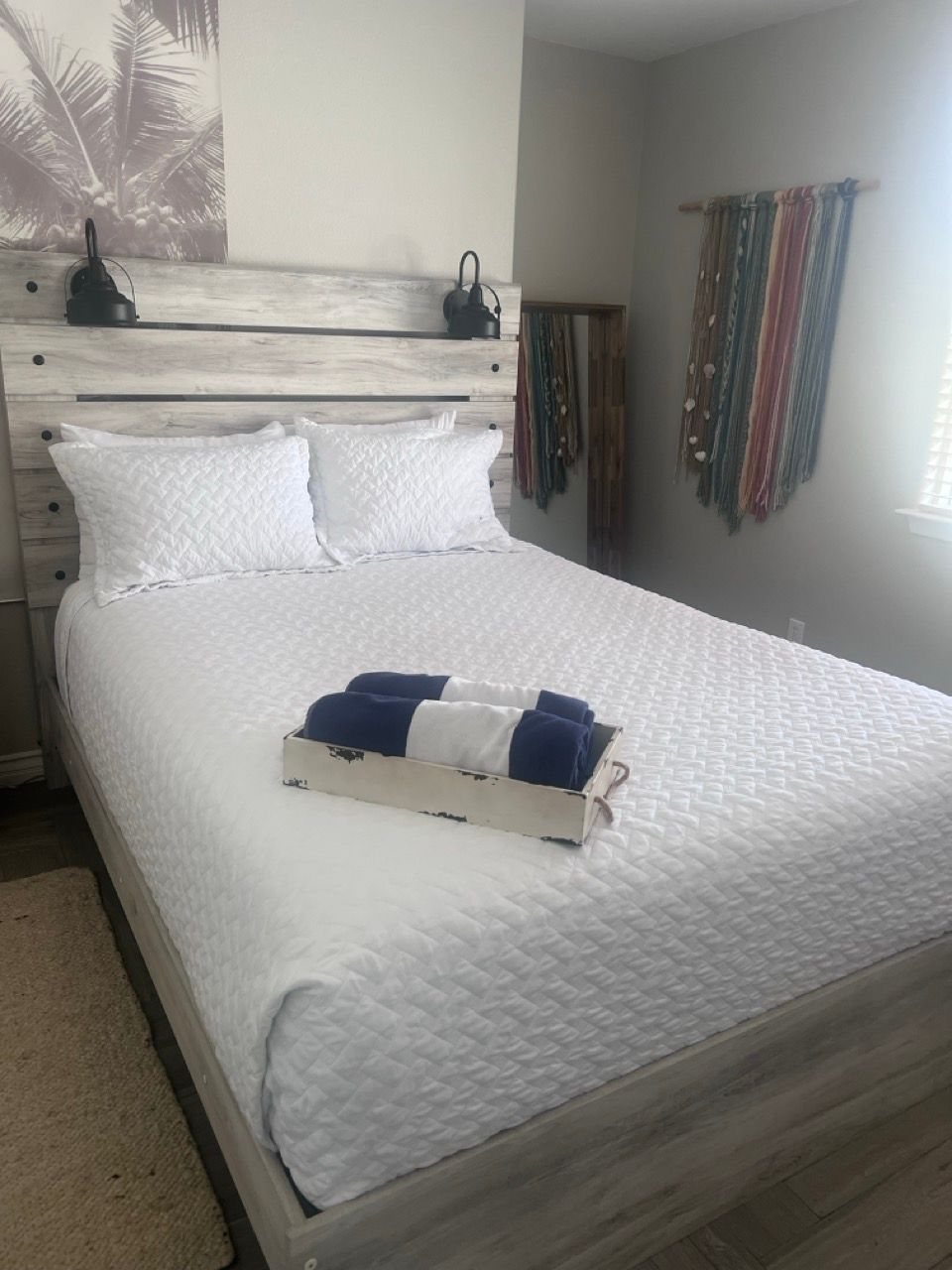 A bed with white sheets and blue towels on it
