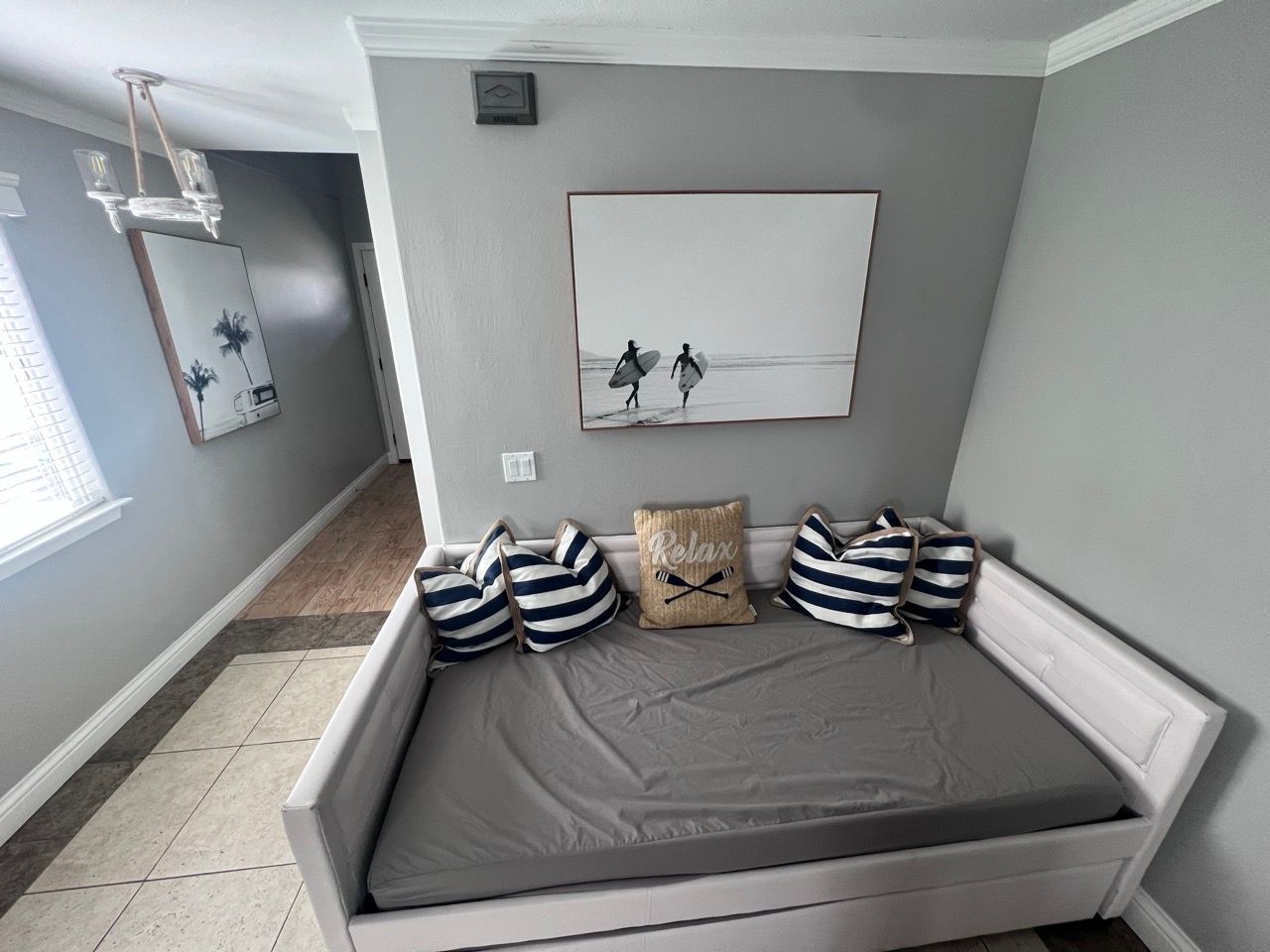 A bedroom with a day bed and a painting on the wall