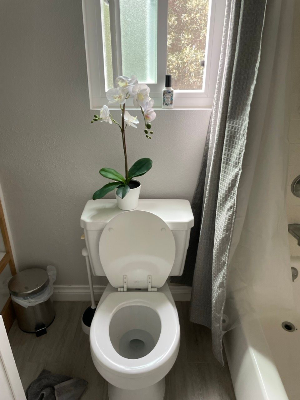 A toilet with a flower on top of it in a bathroom