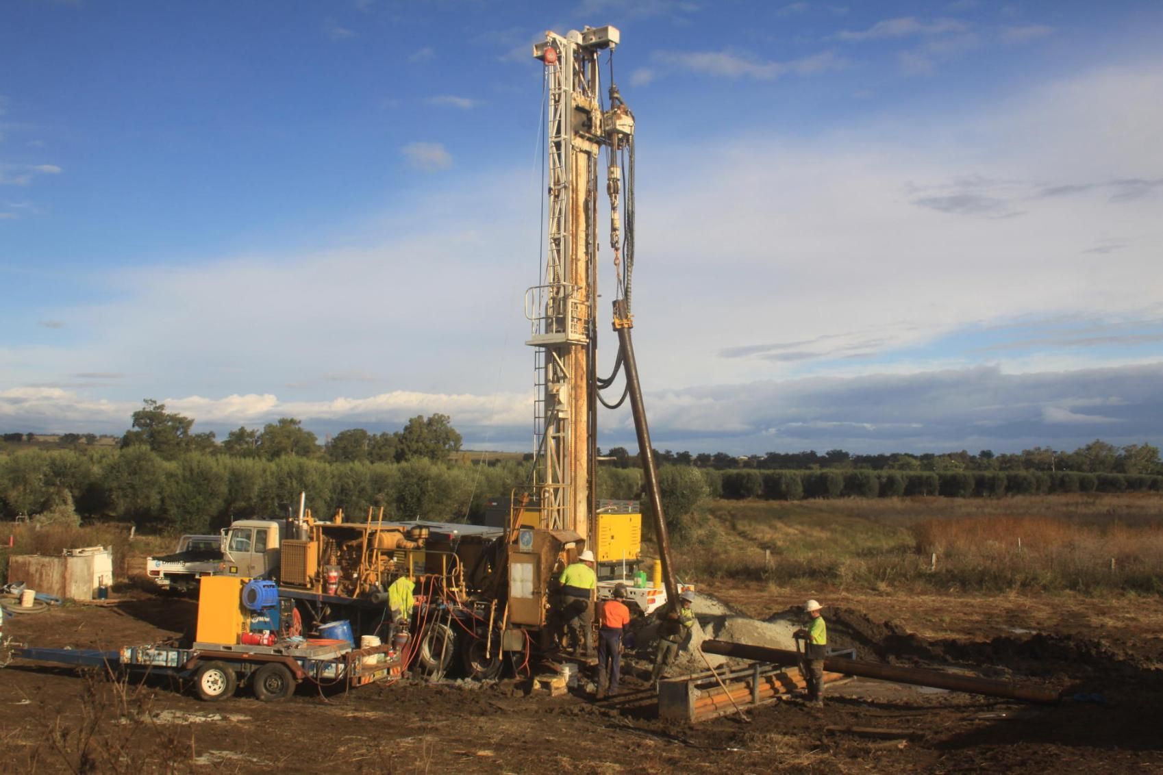 A Group Of People Are Working On A Large Machine In A Field — Water Resources Drilling In Bathurst, NSW