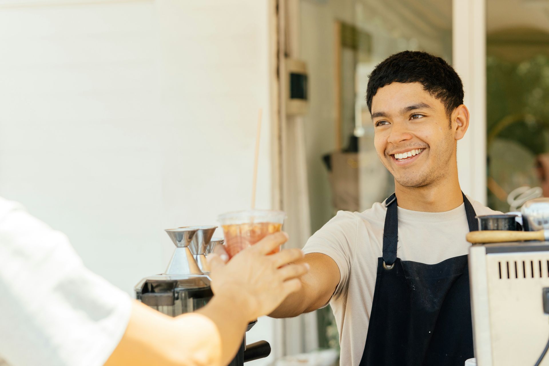 Two workers in safety vests and hard hats examining equipment in a factory.