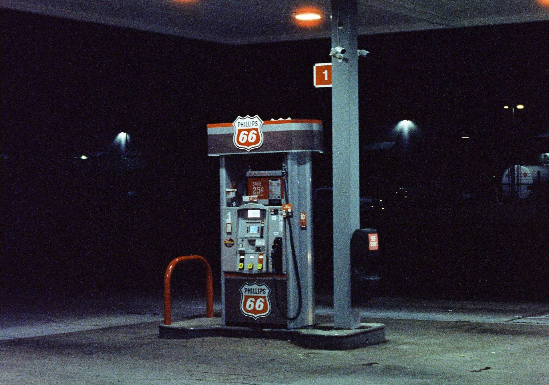 A gas station at night with a sign that says ' fuel ' on it