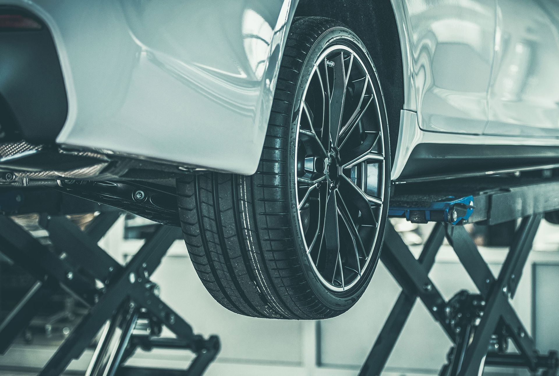 A car is sitting on a lift in a garage.