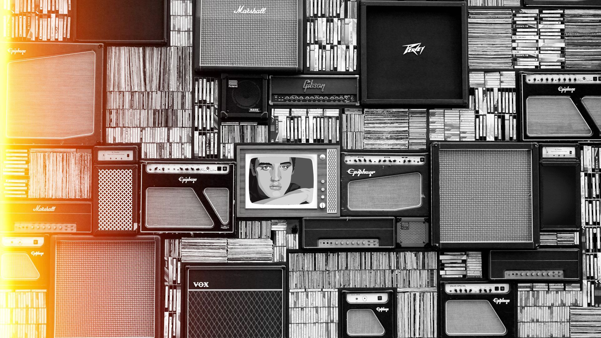 A black and white photo of a wall of televisions and speakers