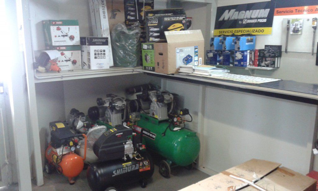 Un montón de compresores de aire están colocados en un estante en una habitación.