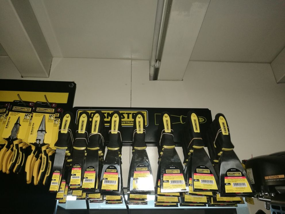 Un montón de herramientas amarillas y negras colgadas en una pared.