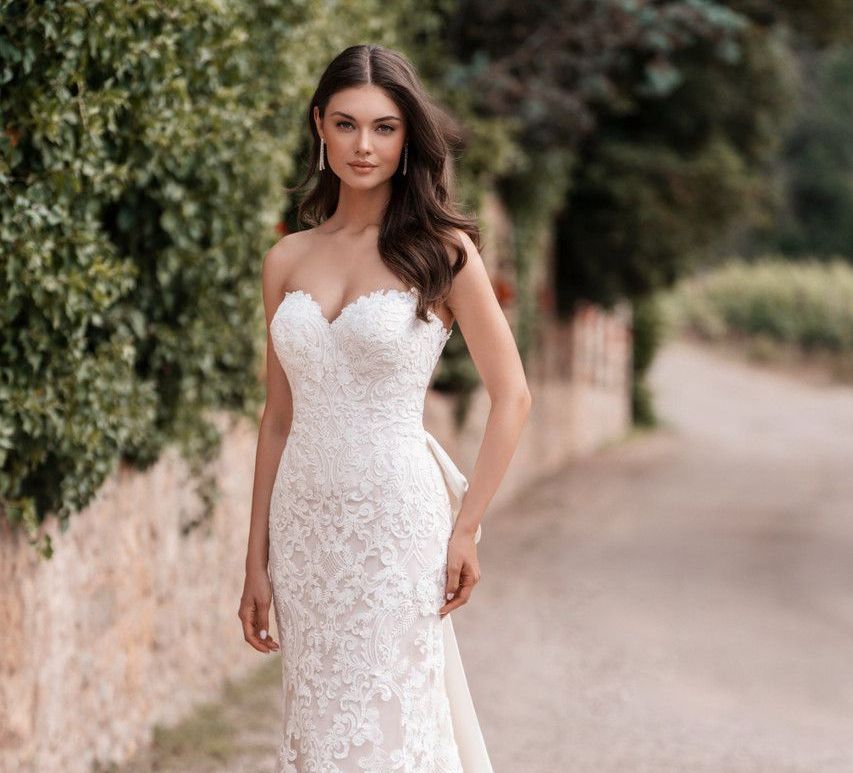 A woman in a wedding dress is standing in a field of flowers.