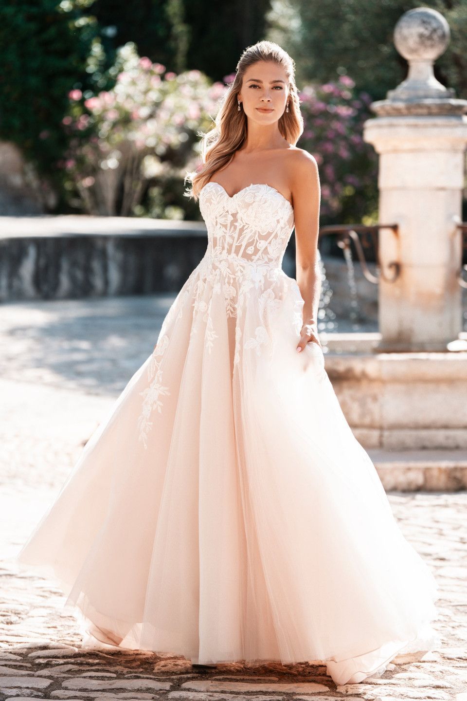 A woman in a white wedding dress is holding a bouquet of flowers