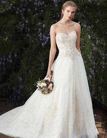 A woman in a white wedding dress is holding a bouquet of flowers.