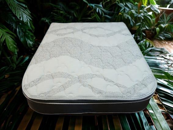 Interior view of a campervan with a bed, open doors revealing a beach view — Coastal Mattress' Direct in South Nowra, NSW