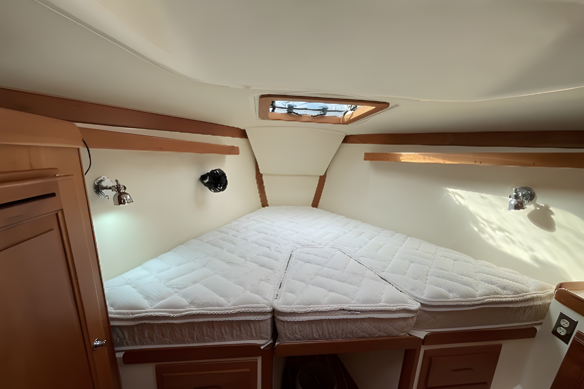 Boat cabin with a bed, wood trim, and a small skylight — Coastal Mattress' Direct in South Nowra, NSW