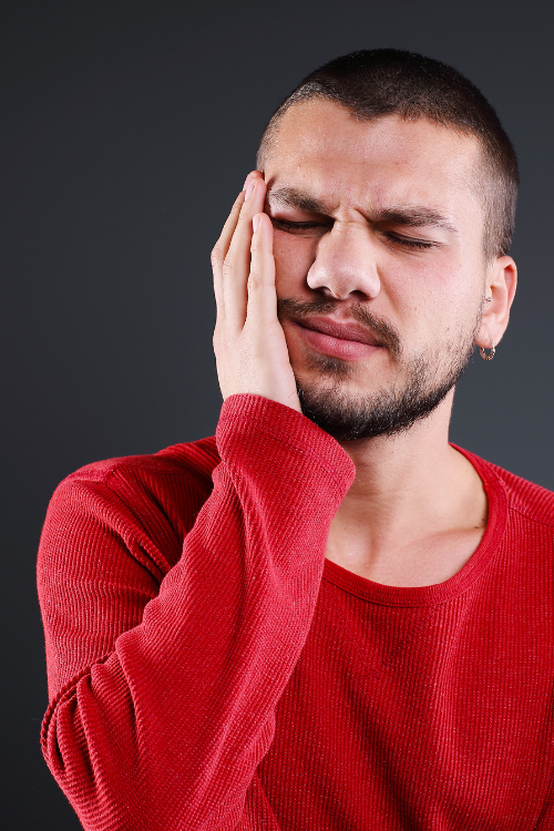 man with tooth pain holding cheek | same day emergency dentist Coraopolis PA
