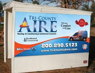 A white trailer with a blue and orange sign that says tri-county aire