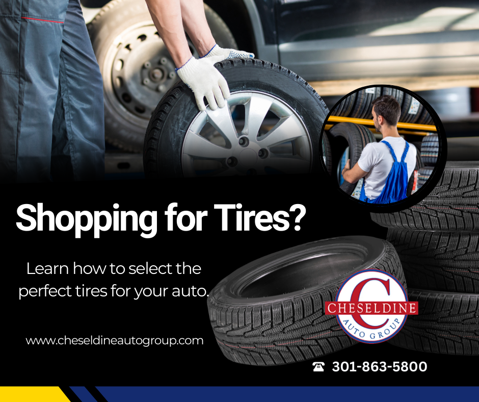 A man is changing a tire on a car in a garage.