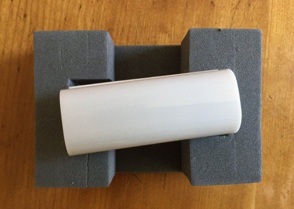 A Google Beacon (white tube) is sitting on a piece of foam