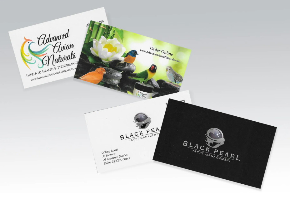 Three business cards are stacked on top of each other on a table.