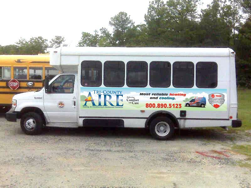 A tri-county aire bus is parked next to a yellow school bus