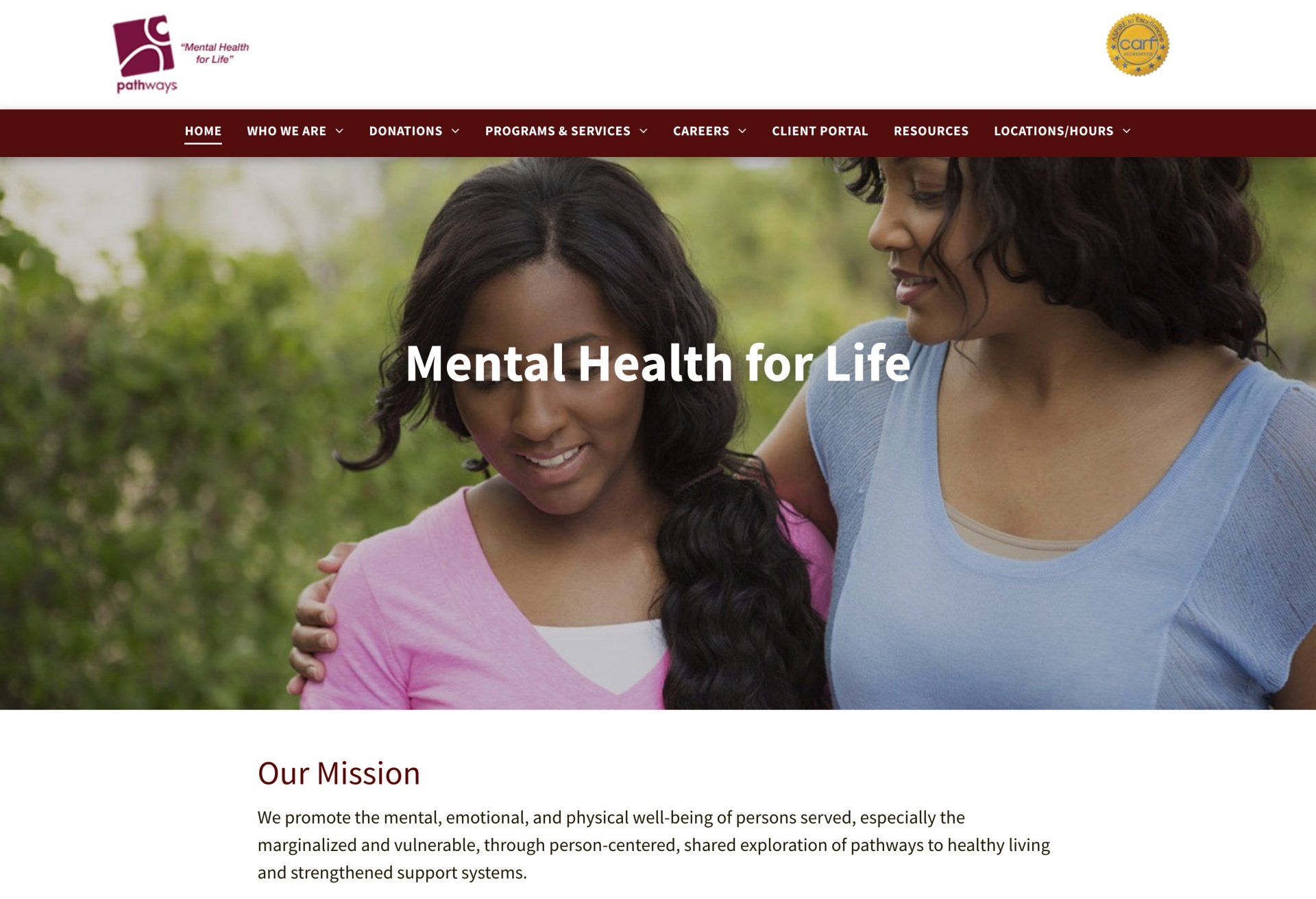 A website for mental health for life shows two women hugging each other.