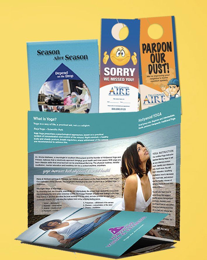 A woman is standing in front of a stack of brochures.