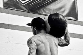 A man is carrying a large bag on his shoulders.