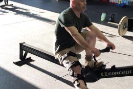 A man with a prosthetic leg is riding a rowing machine.