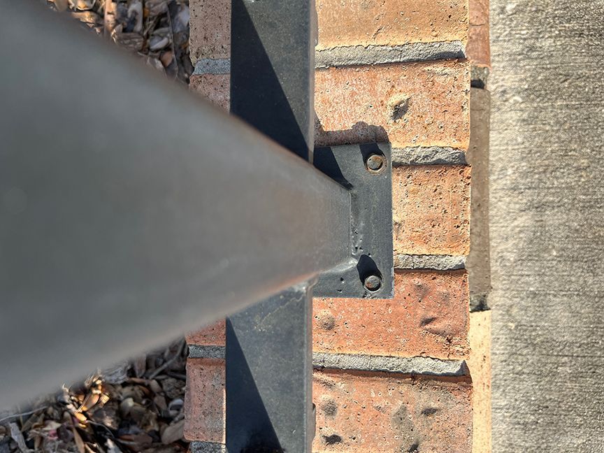 aluminum rail mounted to brick perimeter fence