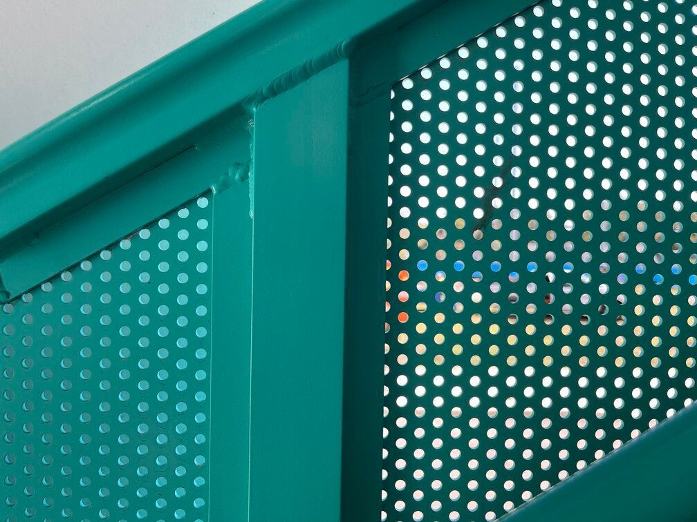 close up of clean powder coating on stair rail with circular mesh infill