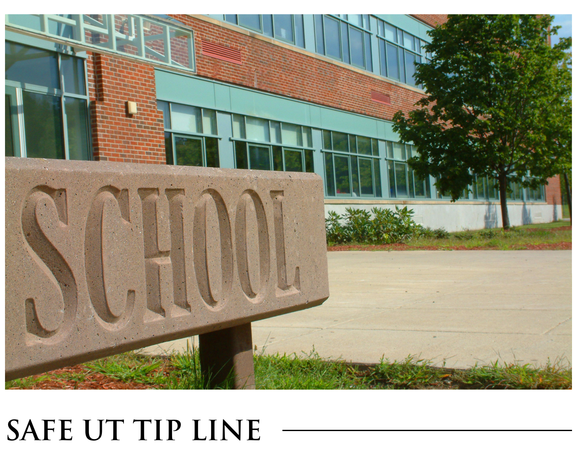 A stone sign that says school in front of a school
