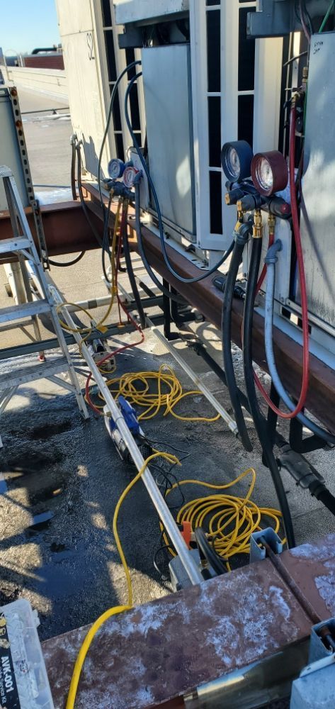 Equipment on a rooftop, with gauges, hoses, and power cords.